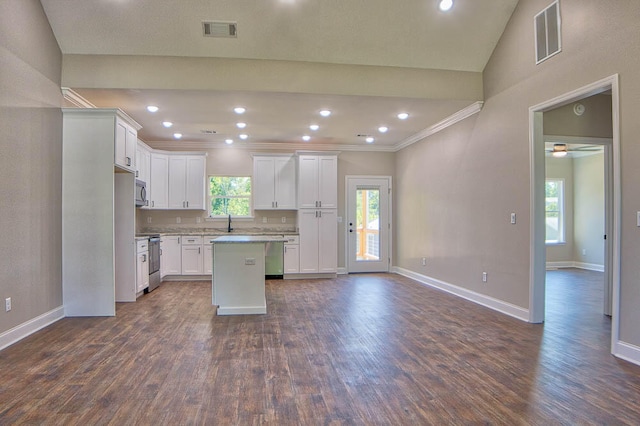 kitchen featuring lofted ceiling, a kitchen island, white cabinetry, and dark wood-type flooring