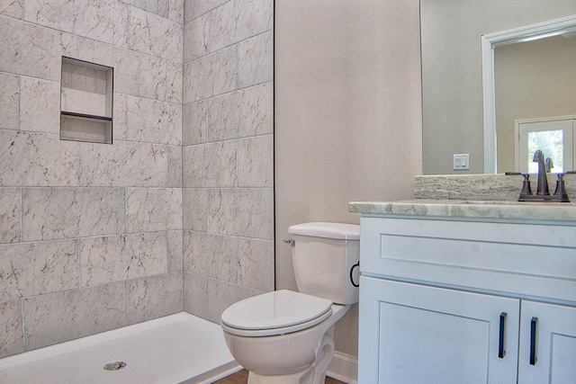 bathroom featuring vanity, toilet, and a shower