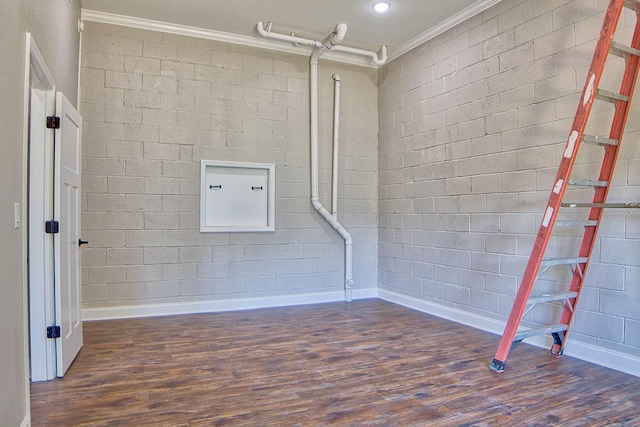 basement with brick wall, ornamental molding, and dark hardwood / wood-style floors