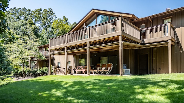 rear view of property featuring a wooden deck and a lawn