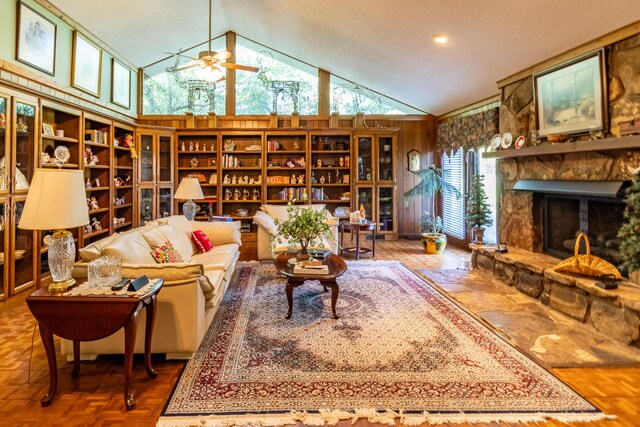 living room with a fireplace, vaulted ceiling, plenty of natural light, and ceiling fan