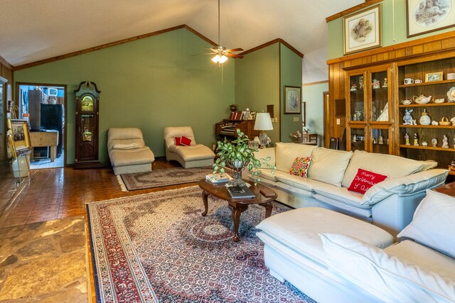 living room with ceiling fan, ornamental molding, and vaulted ceiling