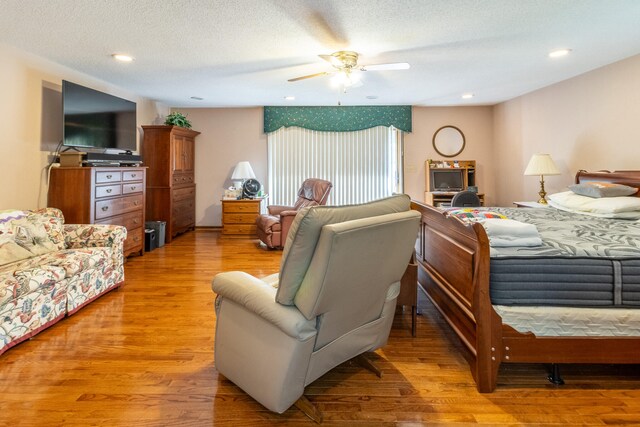 bedroom featuring a textured ceiling, ceiling fan, and hardwood / wood-style floors