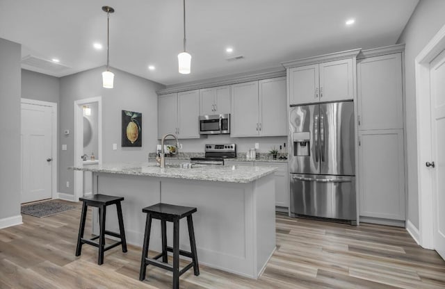 kitchen featuring an island with sink, stainless steel appliances, and light hardwood / wood-style floors