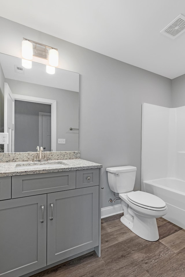 full bathroom with vanity, toilet, wood-type flooring, and shower / bath combination