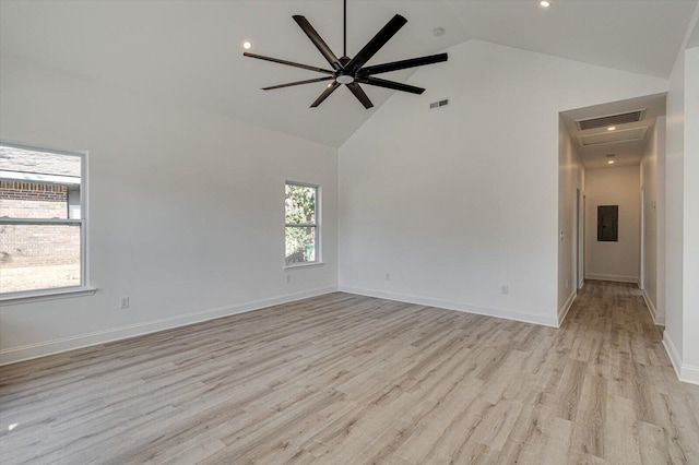 empty room with ceiling fan, a wealth of natural light, high vaulted ceiling, and light wood-type flooring