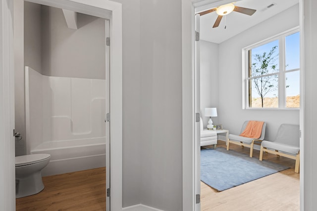 bathroom featuring toilet, hardwood / wood-style floors, ceiling fan, and shower / bath combination