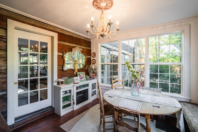 dining room with crown molding, dark wood-type flooring, and a notable chandelier