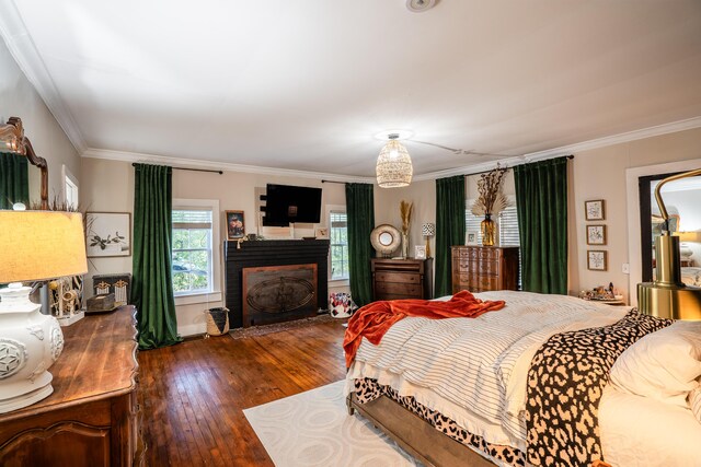 bedroom with dark hardwood / wood-style floors and crown molding