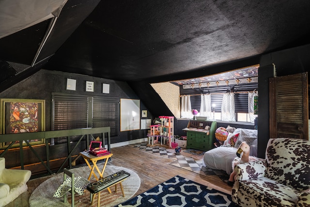 home theater featuring lofted ceiling and hardwood / wood-style floors