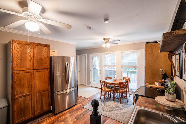 kitchen featuring crown molding, ceiling fan, stainless steel refrigerator, and wood-type flooring