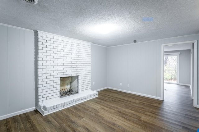 unfurnished living room featuring a fireplace, dark hardwood / wood-style flooring, crown molding, and a textured ceiling