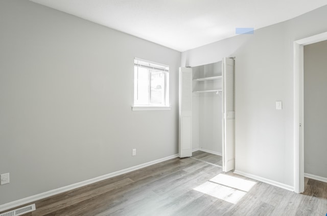 unfurnished bedroom with light hardwood / wood-style flooring and a closet