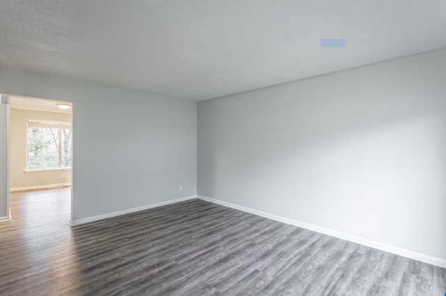 unfurnished room featuring a textured ceiling and dark hardwood / wood-style floors