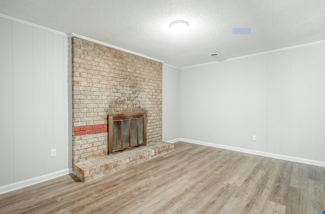 unfurnished living room with a fireplace, a textured ceiling, ornamental molding, and hardwood / wood-style floors