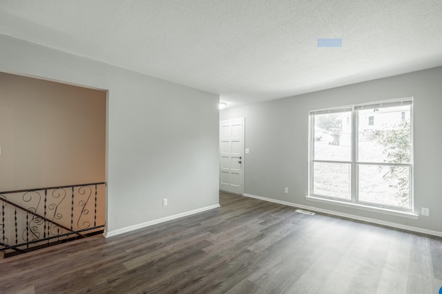 spare room featuring a textured ceiling and hardwood / wood-style floors