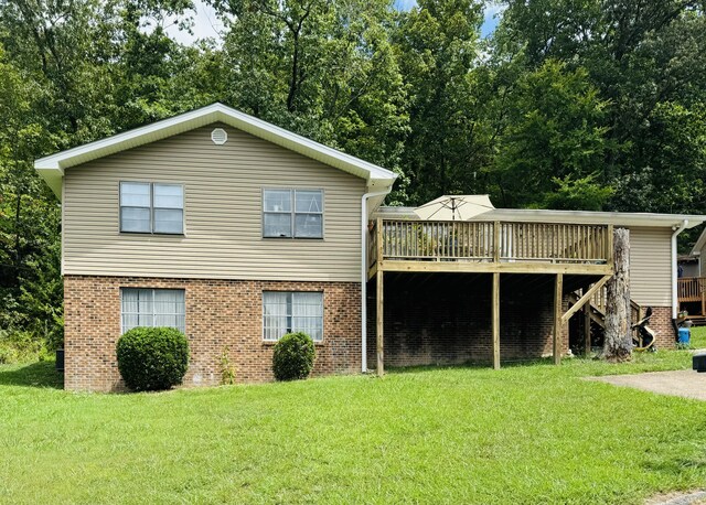 rear view of house featuring a deck and a yard