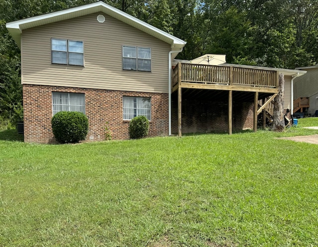 rear view of house featuring a yard and a deck