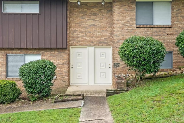 property entrance featuring a lawn