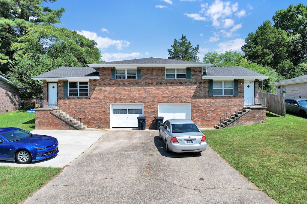 tri-level home featuring a garage and a front lawn