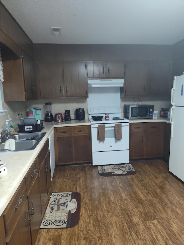 kitchen with sink, white appliances, and dark hardwood / wood-style flooring