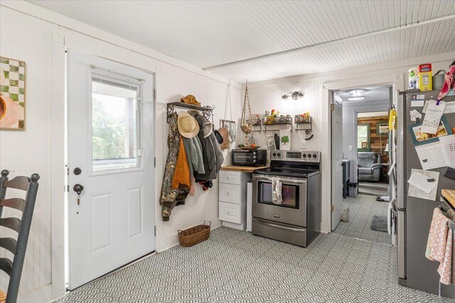 kitchen with wood walls and stainless steel appliances