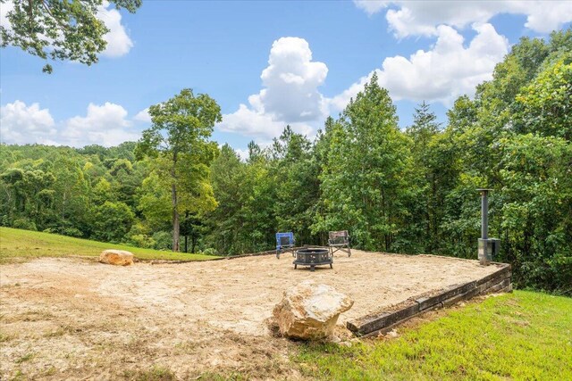 view of property's community featuring a yard and a fire pit