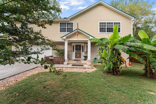 view of front of property featuring a garage, a front lawn, and covered porch