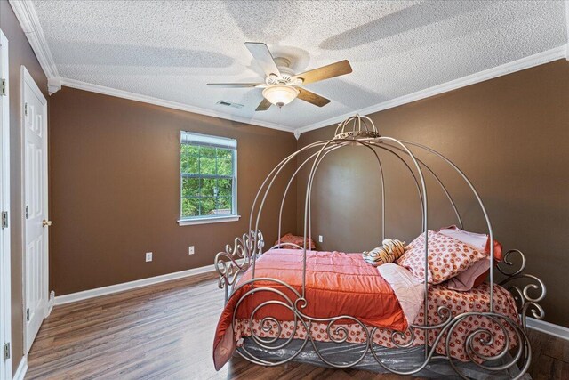 bedroom featuring ornamental molding, ceiling fan, hardwood / wood-style floors, and a textured ceiling