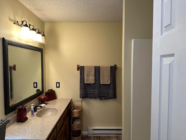 bathroom featuring a baseboard radiator, a textured ceiling, hardwood / wood-style flooring, and vanity