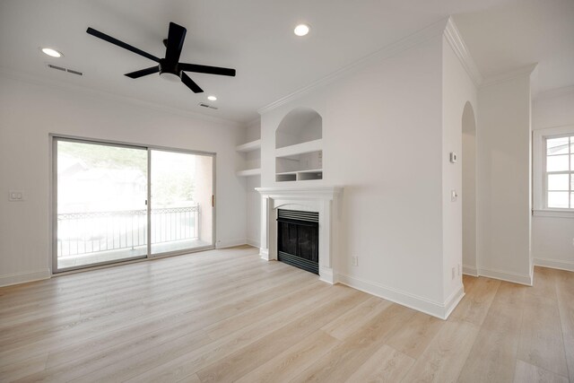 unfurnished living room featuring crown molding, light hardwood / wood-style flooring, ceiling fan, and built in shelves