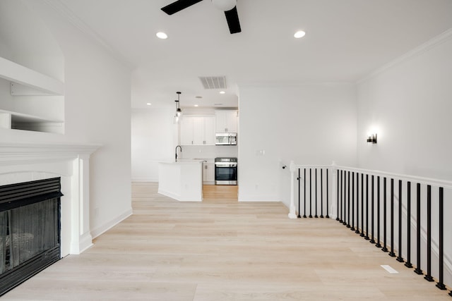 corridor featuring ornamental molding, sink, and light hardwood / wood-style flooring