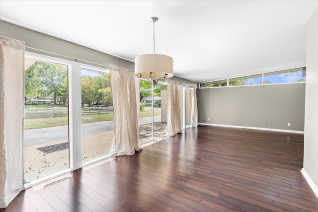 interior space with an inviting chandelier and dark hardwood / wood-style floors