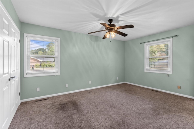 carpeted spare room featuring ceiling fan