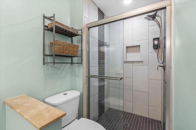 bathroom with a shower with shower door and toilet