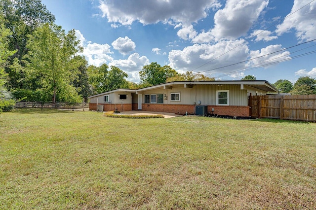 back of property featuring a lawn and cooling unit