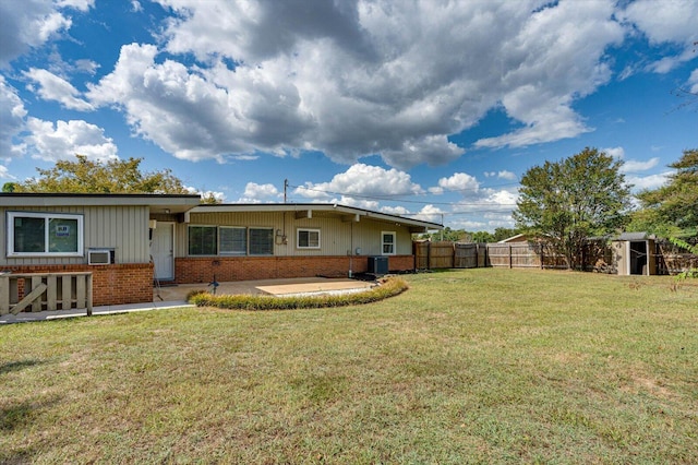 rear view of house featuring a patio, a yard, and central air condition unit