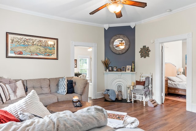 living room with ornamental molding, dark hardwood / wood-style floors, and ceiling fan