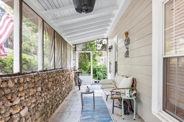 sunroom / solarium with vaulted ceiling with beams