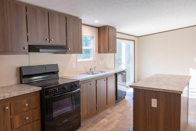 kitchen with black gas range, a center island, sink, stainless steel dishwasher, and light hardwood / wood-style floors