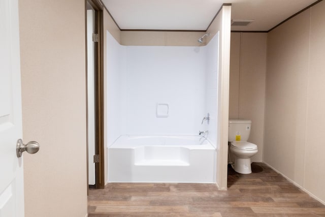 bathroom featuring hardwood / wood-style flooring, toilet, and tub / shower combination