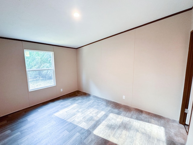 unfurnished room featuring wood-type flooring and ornamental molding