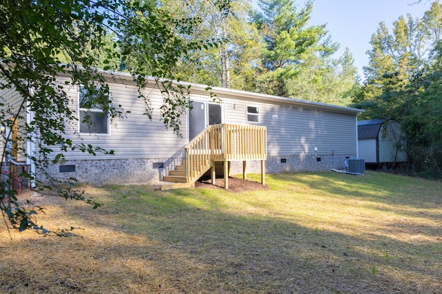 back of house with cooling unit and a yard