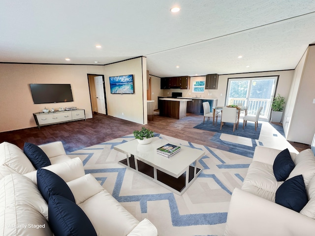 living room with a textured ceiling, light hardwood / wood-style floors, and ornamental molding