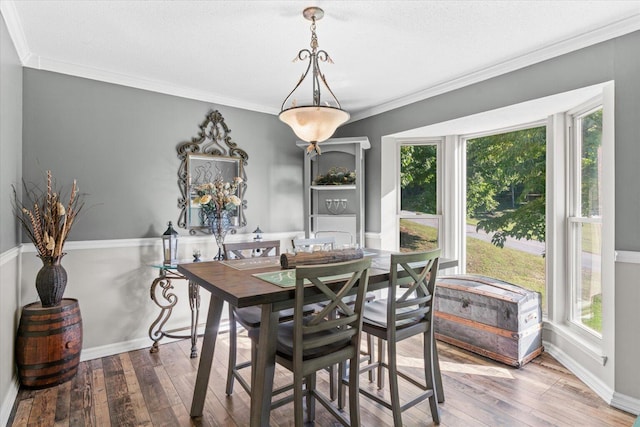 dining space with ornamental molding, a textured ceiling, and wood-type flooring