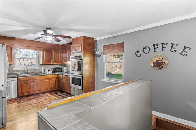 kitchen with tile countertops, ceiling fan, stainless steel appliances, and a healthy amount of sunlight