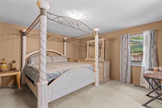 bedroom with light carpet and a textured ceiling