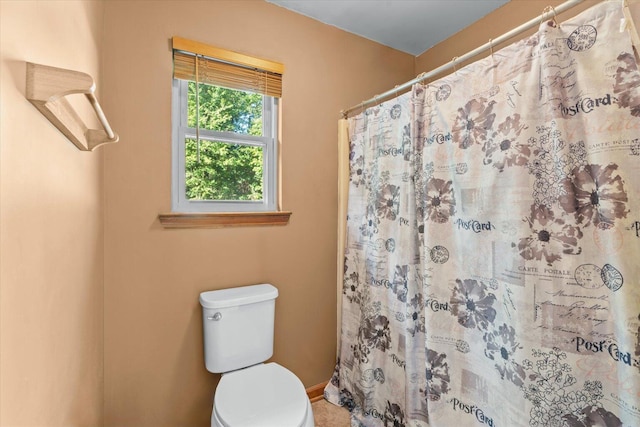 bathroom with a shower with curtain and toilet