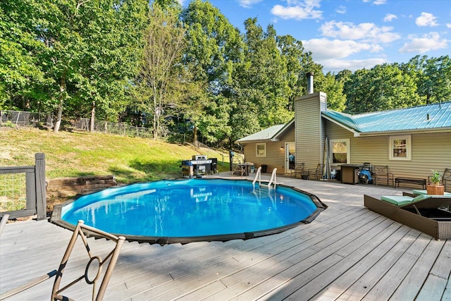 view of pool with a wooden deck and a lawn