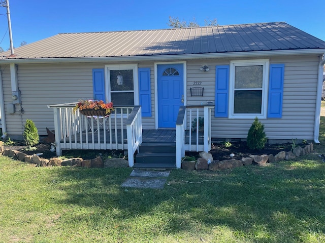 view of front of home with a front yard and a deck